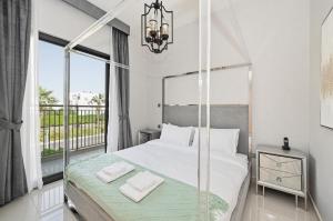 a bedroom with a large bed and a balcony at 3BR Luxurious Villa pool view DAMAC Hills 2 in Dubai +56 photos