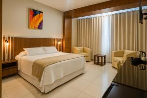 a hotel room with a bed and two chairs at Hotel Maywa in Santa Cruz de la Sierra