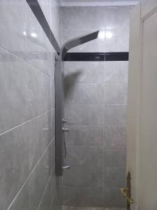een douche met een douchekop in een badkamer bij The Home Apartments in Kolwezi +4 foto's