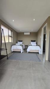 a bedroom with two beds and a large window at Izinga Game Karoo Guest Farm in Philipstown