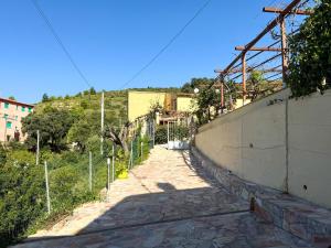 a sidewalk next to a wall with a hill in the background at La Dimora di Bagnaja - HelloElba in Bagnaia