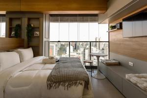a bedroom with a large bed with a large window at Yume On Paulista in São Paulo