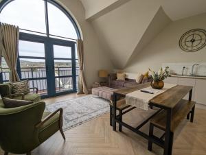 een woonkamer met een tafel en een groot raam bij Waterfoot Penthouse Apartment in Newcastle
