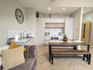 een woonkamer met een bank en een tafel bij Waterfoot Penthouse Apartment in Newcastle