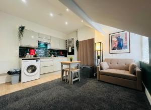 ein Wohnzimmer mit Couch und Küche in der Unterkunft Yastayzzz at Apartment 4 Worcester House in Worcester + 8 Fotos