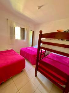 Dos camas en una habitación con sábanas rosas. en Chácara Aconchegante Vista Linda com Roupa de Cama, en Socorro 14 fotos más