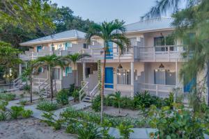 a building with palm trees in front of it at Blue Reef Beach and Marina in Placencia