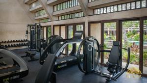 ein Fitnessstudio mit Laufbändern und Geräten in einem Gebäude in der Unterkunft Peregrina Tulum 110 1BR Condo with Jacuzzi in Tulum