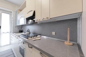 a kitchen with white cabinets and a counter top at PrimoPiano - Don Gnocchi in Bresso