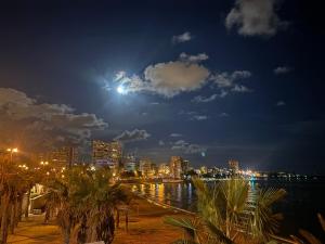 een skyline van een stad 's nachts met volle maan bij The luxury suite in Alicante