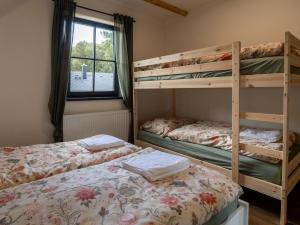 Un dormitorio con dos literas y una ventana. en Chalupa Jesenka, en Sobotín