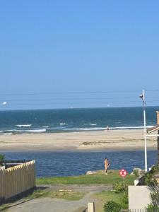 een persoon die op het strand bij de oceaan loopt bij Ótimo apartamento com ampla sacada e vista pro mar in São Francisco do Sul