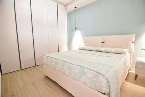 ein weißes Schlafzimmer mit einem Bett und weißen Schränken in der Unterkunft Ti porto al mare in Marina di Ragusa + 5 Fotos