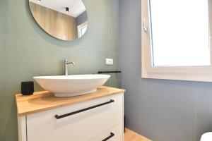 ein Badezimmer mit einem weißen Waschbecken und einem Spiegel in der Unterkunft Ti porto al mare in Marina di Ragusa