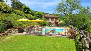 a pool with chairs and umbrellas and a house at La Scatolaia in Stia