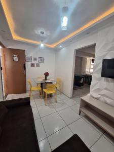 un soggiorno con tavolo e sedie gialle di Apto Aconchegante Be life I a 4km das praias a São Luís