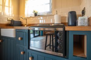 eine Küche mit einer Theke und einem Herd Oberer Backofen in der Unterkunft Friels Fairy Tree Hawthorn lodge in Swatragh