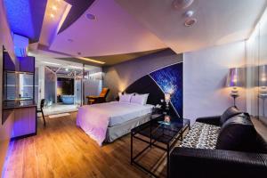 a bedroom with a bed and a living room with a couch at TY Motel in Dayuan