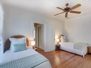 a bedroom with two beds and a ceiling fan at Elsewhere on Tybee in Tybee Island +39 photos