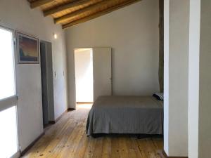 a bedroom with a bed and a wooden floor at Casa Titi in Arroyo de Los Patos