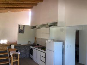 a kitchen with a white refrigerator and white cabinets at Casa Titi in Arroyo de Los Patos +14 photos