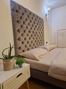 een bed met een groot gewatteerd hoofdeinde in een slaapkamer bij Vila Timeea in Statjunea Borsa