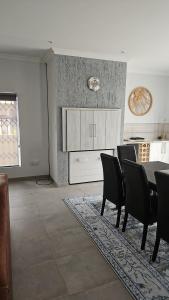 a dining room with a table and black chairs at Atlantis in Hentiesbaai +7 photos