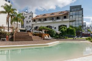 ヴィラ・カルロス・パスにあるHotel El Condadoの建物の前のプール