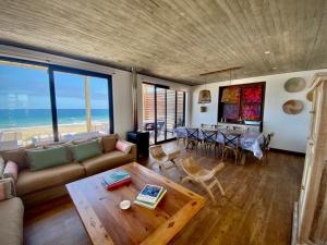 een woonkamer met een bank en een tafel bij Increíble casa primera lineal Playa Morrillos in La Hacienda