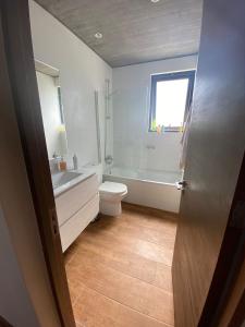 een badkamer met toilet, bad en wastafel bij Increíble casa primera lineal Playa Morrillos in La Hacienda