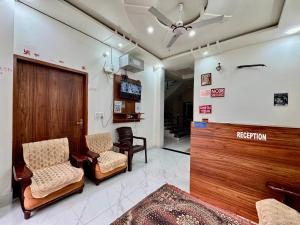 a waiting room with two chairs and a television at Shree Hanumat Kripa Dham in Vrindāvan +24 photos