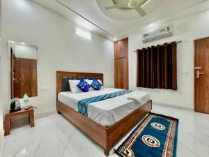 a bedroom with a bed with blue pillows at Shree Hanumat Kripa Dham in Vrindāvan