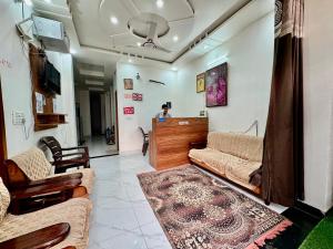 a living room with couches and a person in the background at Shree Hanumat Kripa Dham in Vrindāvan
