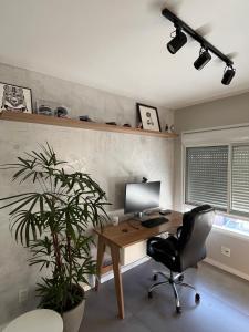 an office with a desk with a computer and a plant at 1 Dorm - Alto Padrão - 16 Andar - Home Office in Porto Alegre