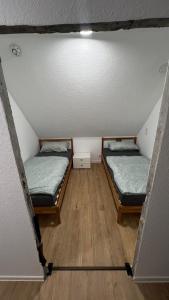 two beds in a small room with a ceiling at Ferienwohnung Maichingen in Sindelfingen