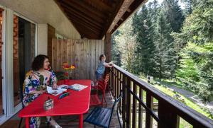 una donna seduta a un tavolo in veranda con un bambino di Chèvreroche a La Bresse