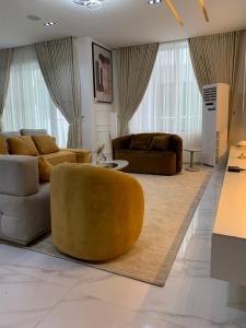 a living room with two couches and a table at Aklass Apartments in Lekki