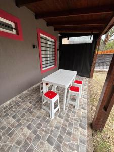 a picnic table and two stools on a patio at Beach House and Nature in Aguas Verdes