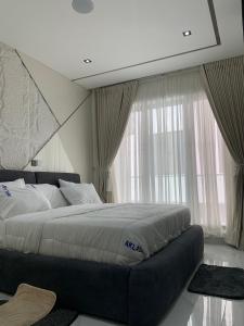 a bedroom with a large bed in front of a window at Aklass Apartments in Lekki
