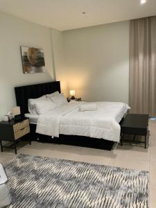 a bedroom with a large white bed and a rug at Nuchi studio in Dubai