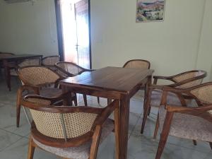 un tavolo e delle sedie di legno in una stanza di Castle Inn Mussoorie Road DEHRADUN a Rājpur