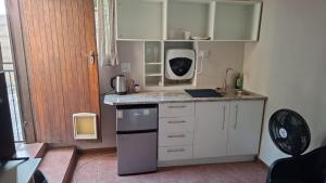 a small kitchen with white cabinets and a sink at MDA Myburgh in Brackenfell