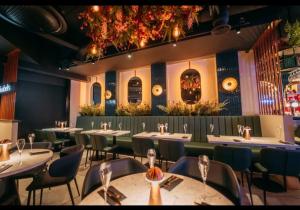 a restaurant with tables and chairs in a room at Burton Urban Apartment in Burton upon Trent