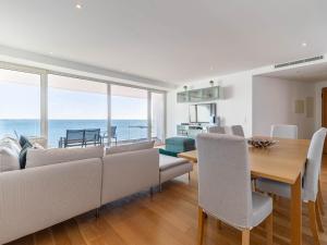 a living room with a couch and a table with chairs at Akicity Jamor Lyra in Cruz Quebrada