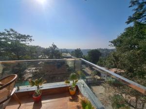 balcone con vista e piante in vaso. di Castle Inn Mussoorie Road DEHRADUN a Rājpur