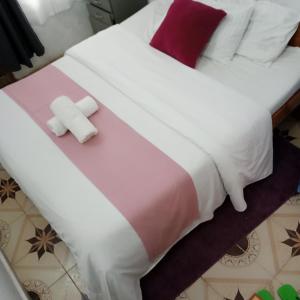 a bed with white and pink sheets and pillows at Accomodation bnb in Ruiru