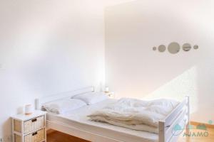 Cama blanca en habitación con pared blanca en 104 - Studio, dans une résidence les pieds dans l'eau à Sables D'or Les Pins, en Sables-dʼOr-les-Pins