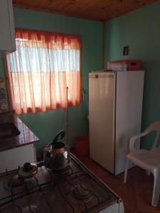 Casa Aleluna في فيلا جياردينو: مطبخ مع موقد وثلاجة بيضاء