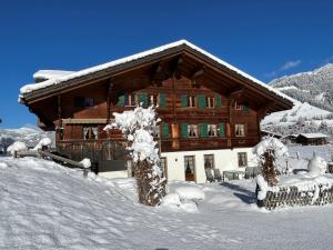 a large wooden house with snow on it at Alpenchalet Spiher Ferienwohnung-Studio und ein weiteres Schlafzimmer in Gstaad