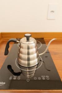 ein Teekessel steht auf einem Herd in der Unterkunft Monte Paraíso - banheira e vista da Pedra Menina in Espera Feliz